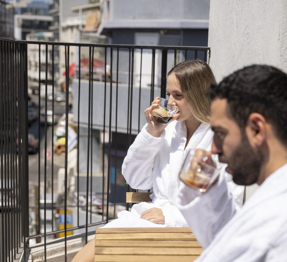 Guests in bathrobes sipping coffee on the balcony