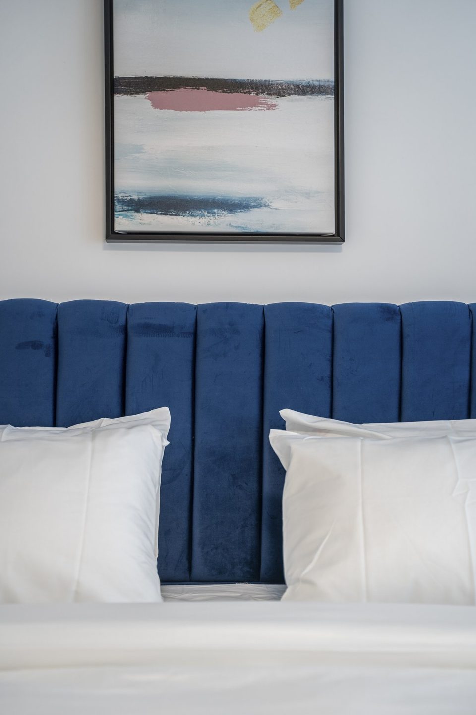 Blue velvet headboard with wall art