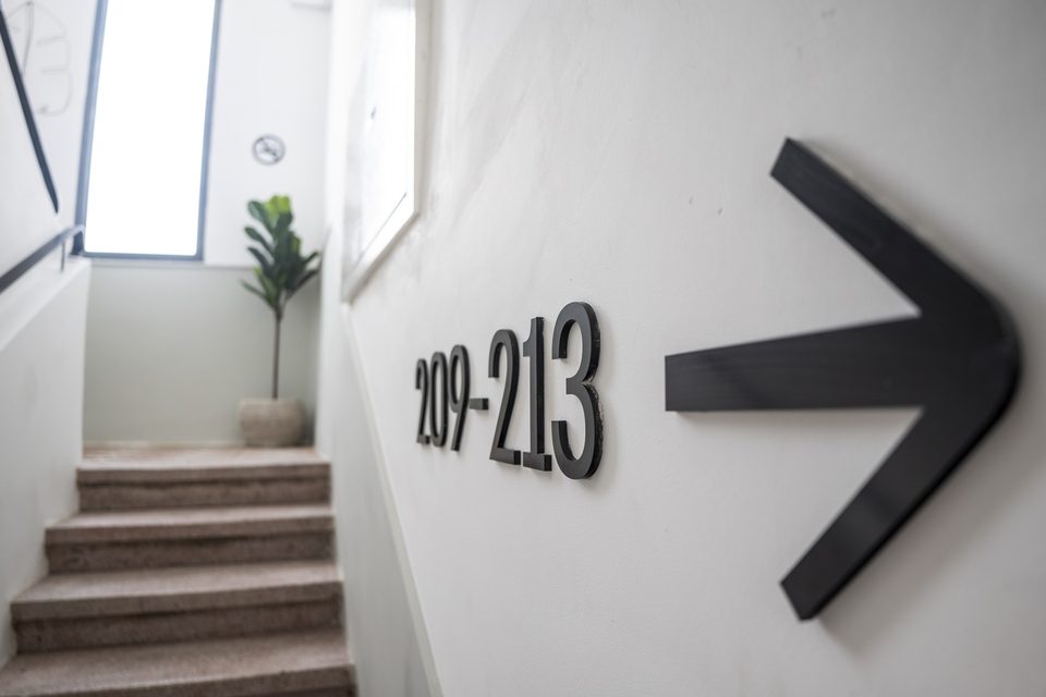 Direction sign to rooms 209–213 in the hotel passage