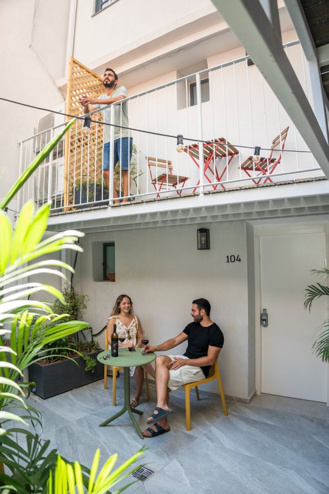Hôtes avec du vin dans la cour, sous le balcon d'une chambre