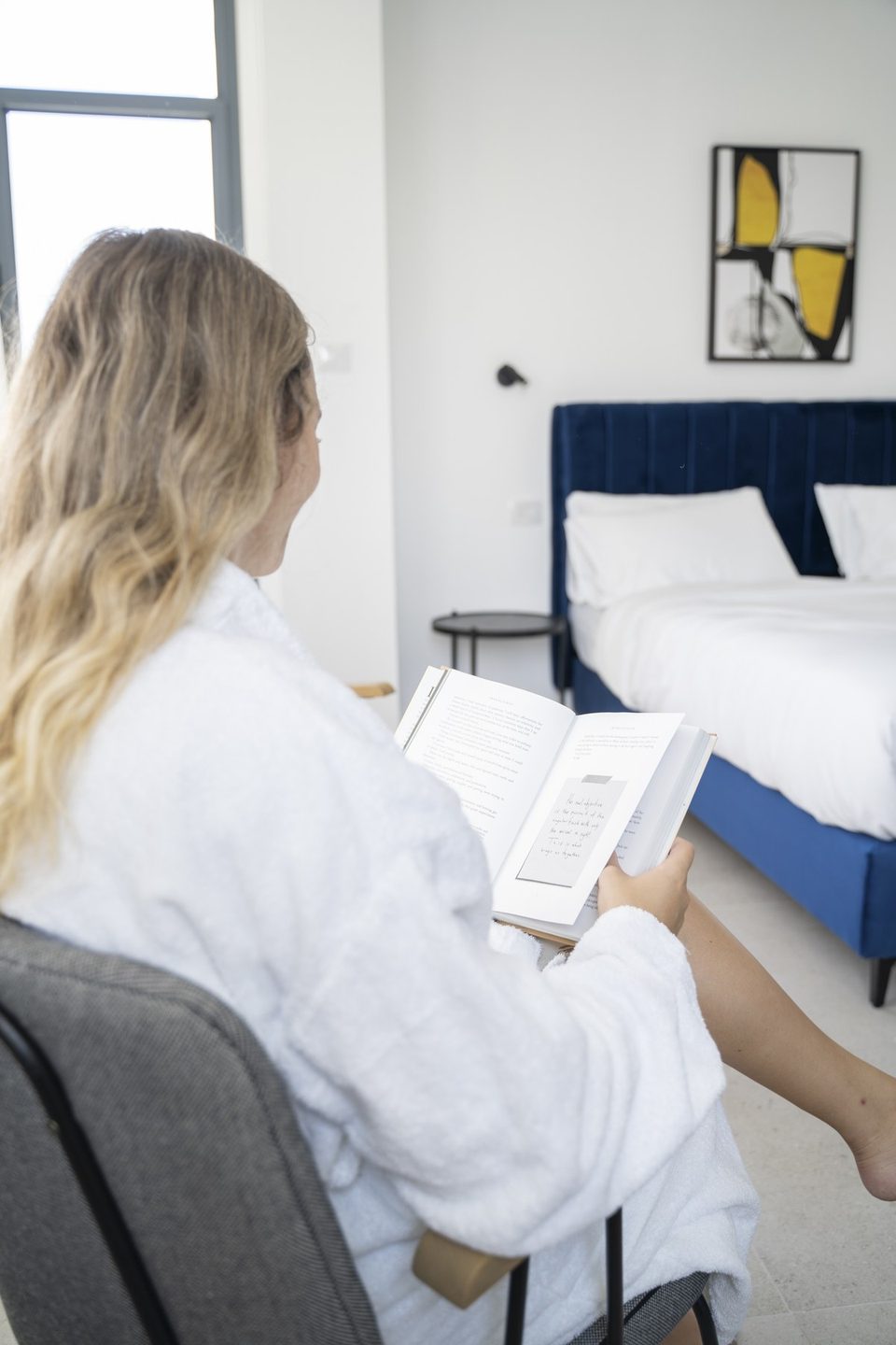 A guest reading a book in the room's seating corner