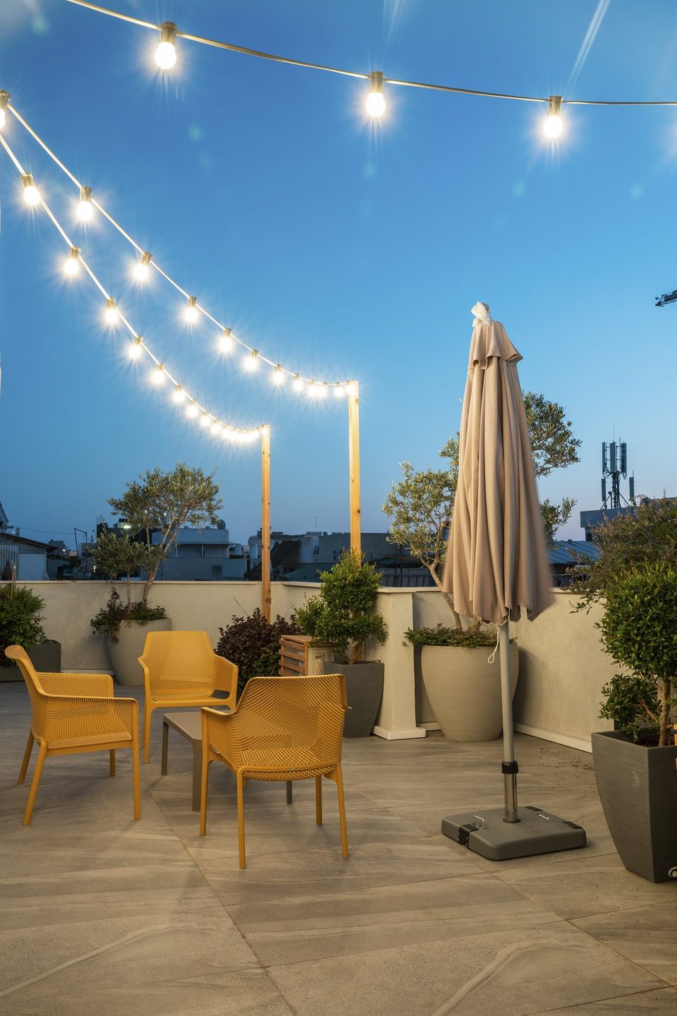 String lights and chairs on the rooftop in the evening