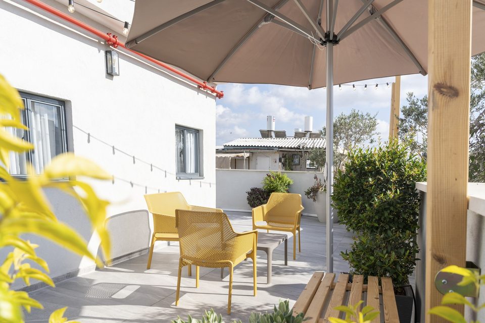 Yellow chairs and a small table on the rooftop