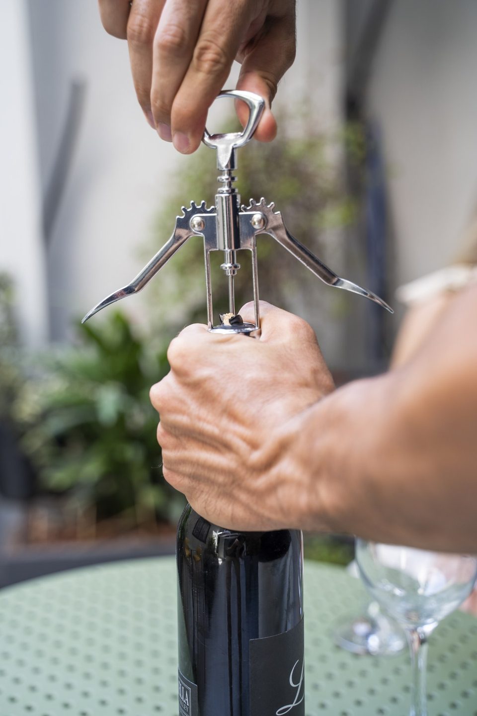 A corkscrew and wine bottle on a courtyard table